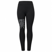 A pair of black leggings with decorative white patterns on the lower left leg.